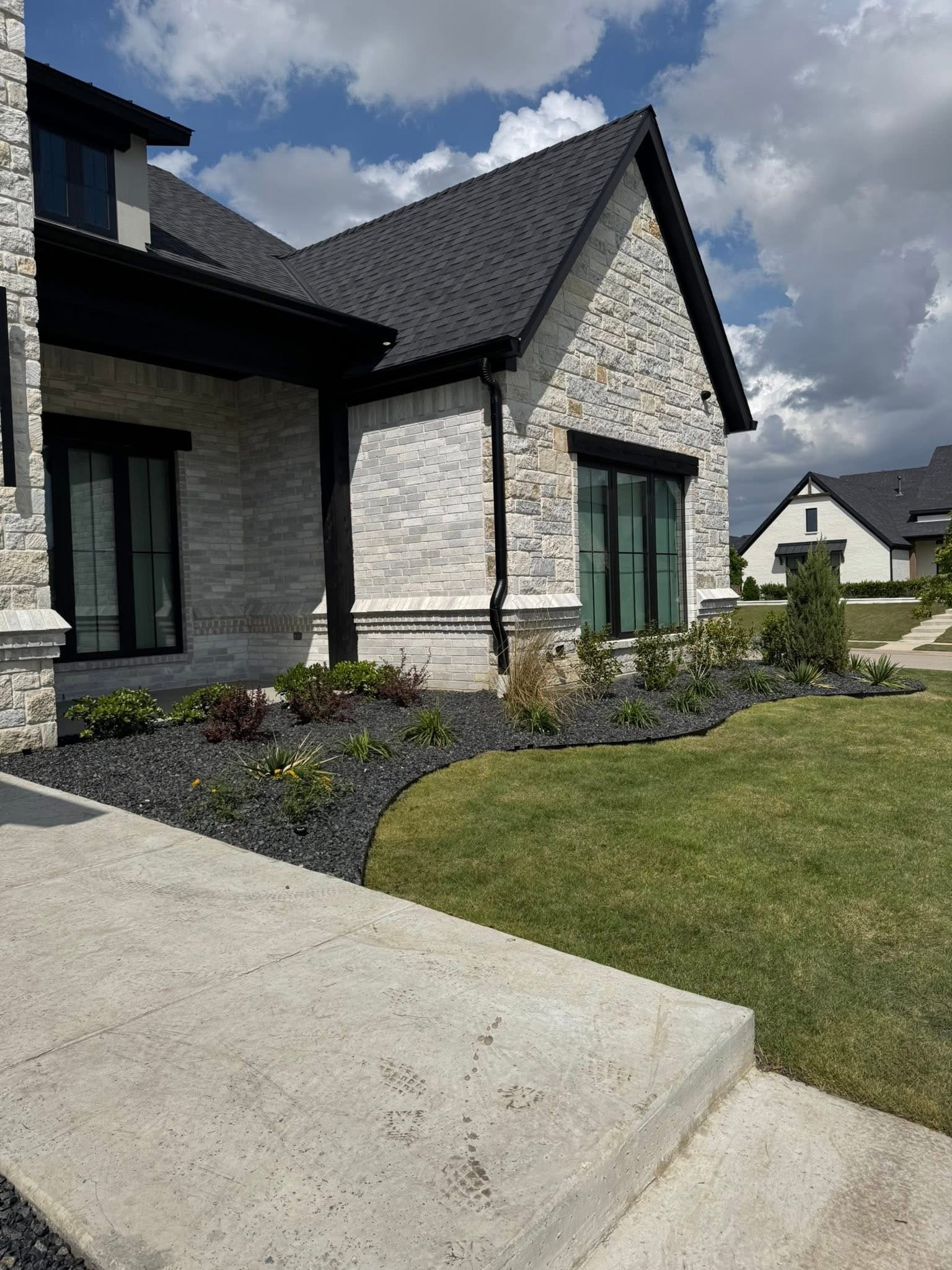 Black decorative aggregate around home foundation landscaping